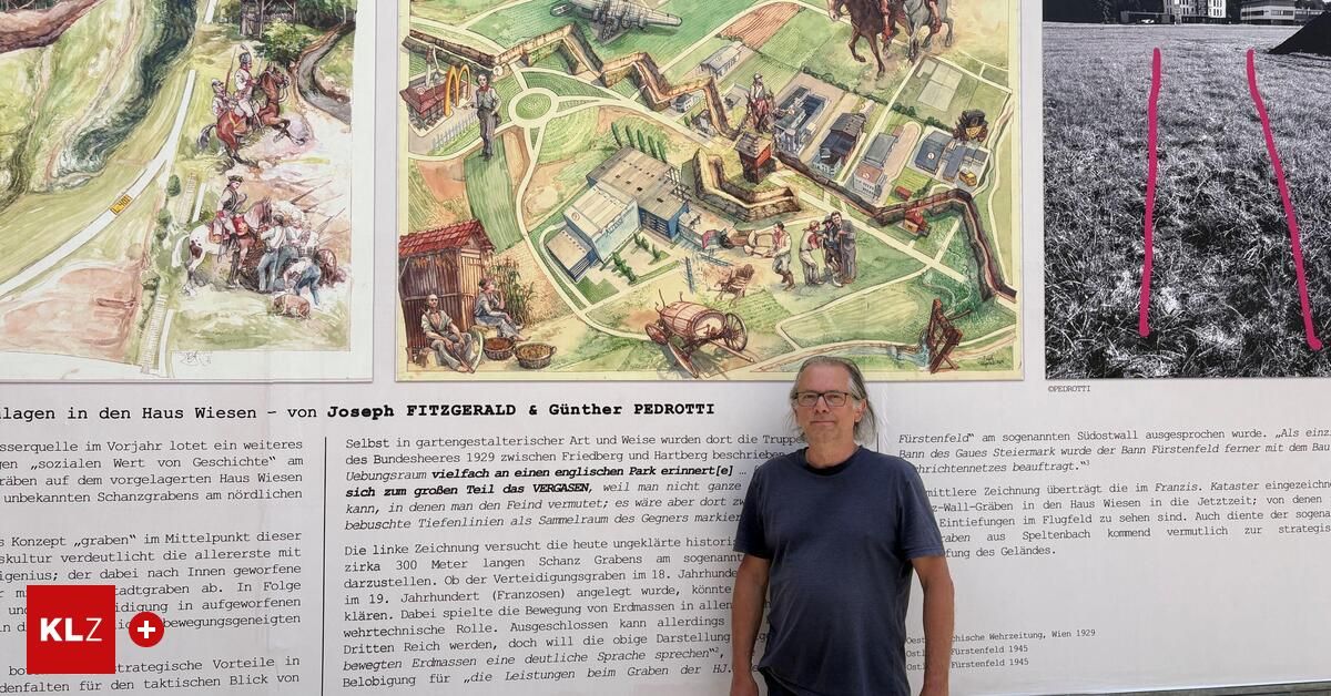 A man stands in front of a large mural depicting a historical scene with people, buildings, and horses. The mural is part of a larger piece that includes text in German.