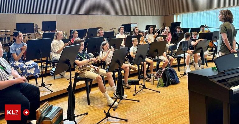 Ein Schulband-Probe mit Schülern, die verschiedene Instrumente wie Saxophon, Geige und Flöte spielen, in einem gut beleuchteten Raum mit Holzböden.