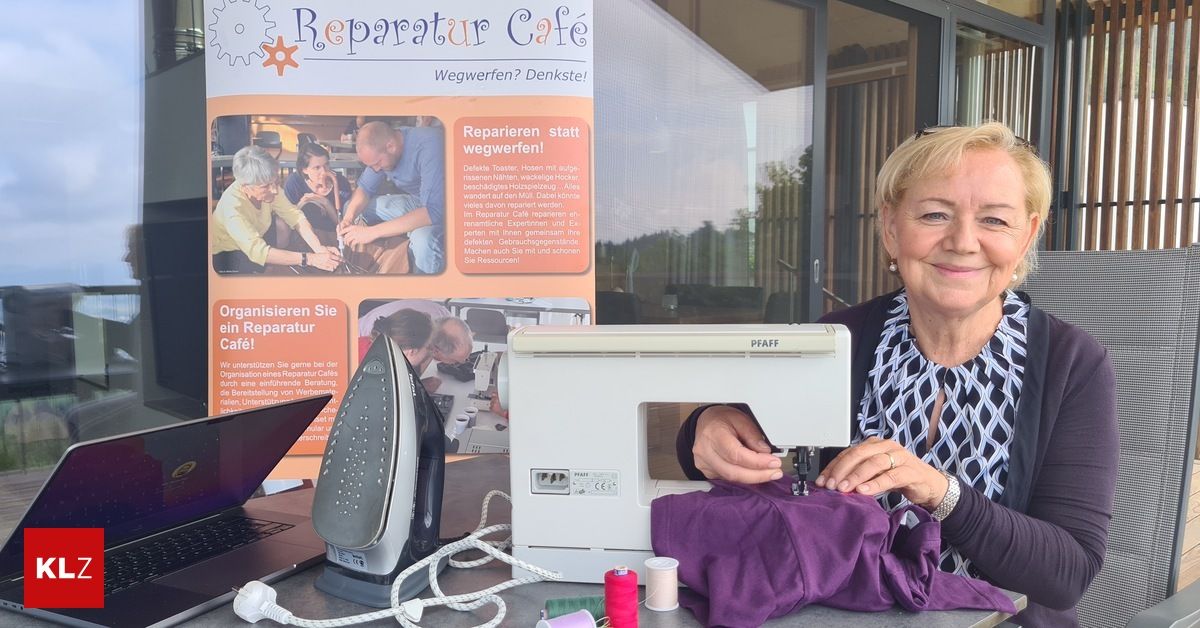 Eine Frau sitzt an einem Tisch mit einer Nähmaschine, einem Bügeleisen und einem Laptop. Hinter ihr ist ein Plakat, das einen Reparaturcafé bewirbt.