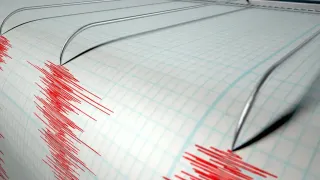 Eine Nahaufnahme eines Seismographenpapiers mit einem roten Wellenmuster, das seismische Aktivität anzeigt.
