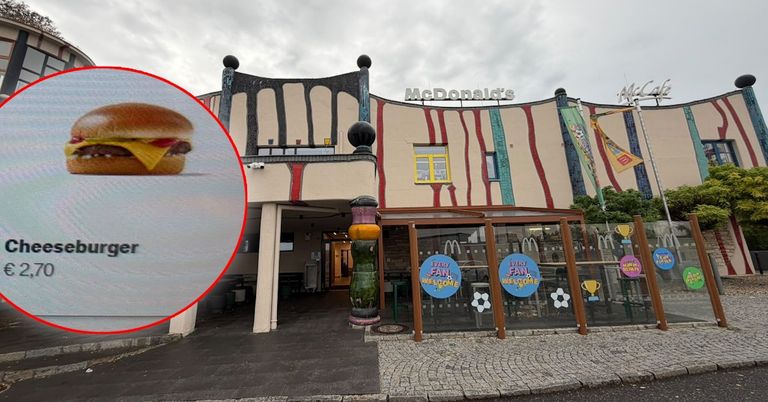 A McDonald's restaurant with a colorful exterior, featuring a burger in a red circle inset. The building has a modern design with a yellow and red striped facade.