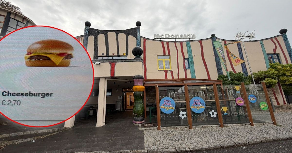 A McDonald's restaurant with a colorful exterior, featuring a burger in a red circle inset. The building has a modern design with a yellow and red striped facade.