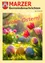 Ein lebhaftes Bild von bunten Ostereiern auf einem Grasfeld mit Tulpen und anderen Blumen im Hintergrund, mit den Worten 'Frohe Ostern!' in Pink geschrieben.