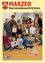 Eine Gruppe von Kindern und Erwachsenen posiert für ein Foto, einige halten Bücher und andere lächeln. Der Hintergrund scheint ein Klassenzimmer oder eine Bibliothek zu sein, mit Büchern auf Regalen im Hintergrund.