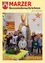 Eine Gruppe von Kindern in Winterkleidung steht um eine mit Kerzen bestückte Adventskrone herum, mit einem Mann als Sankt Nikolaus dahinter.