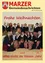 Eine Gruppe von Frauen in traditioneller Kleidung posiert für ein Foto vor einem festlichen Hintergrund mit der Aufschrift 'Frohe Weihnachten'. Die Frauen lächeln und scheinen einen Feiertag zu feiern.
