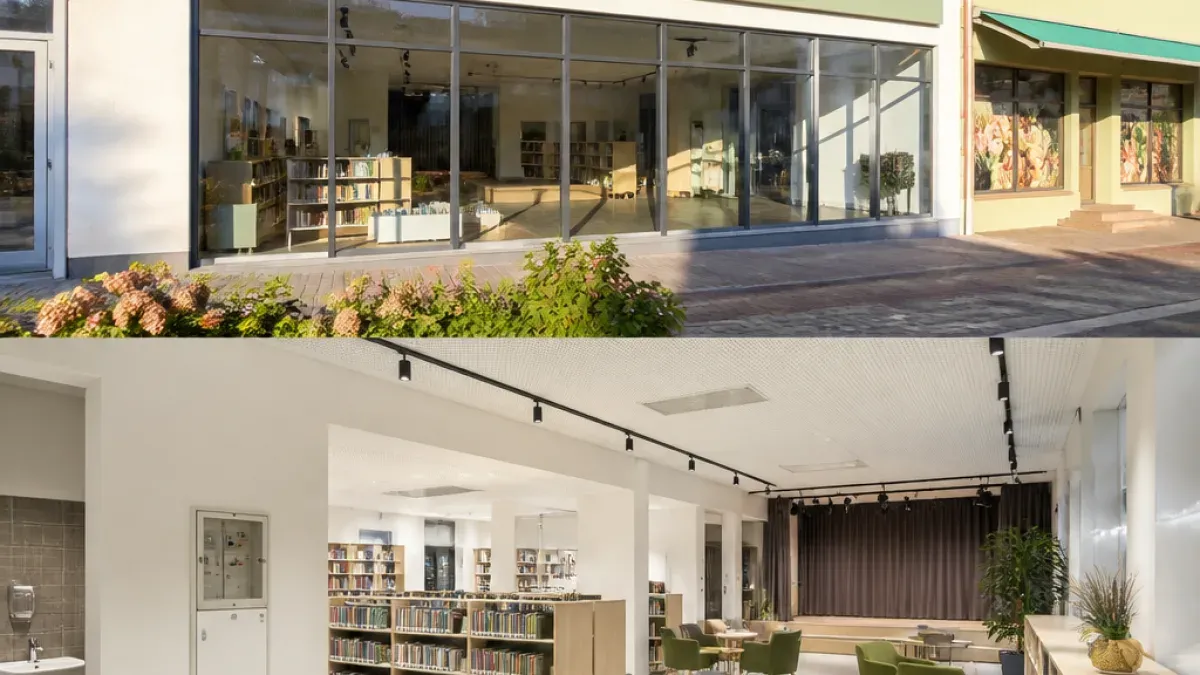 A modern library with large glass windows and a well-lit interior. Shelves filled with books are visible, and there are chairs and tables in the reading area.