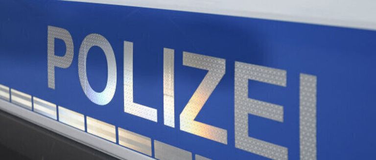 A close-up view of the word 'POLIZEI' in bold, silver letters on a blue background. The letters have a metallic texture and are slightly reflective.