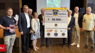 Eine Gruppe von Menschen hält ein großes Schild mit der Aufschrift Lions Club und einem Spendenbetrag von 38.000 Euro. Sie lächeln und posieren für ein Foto.
