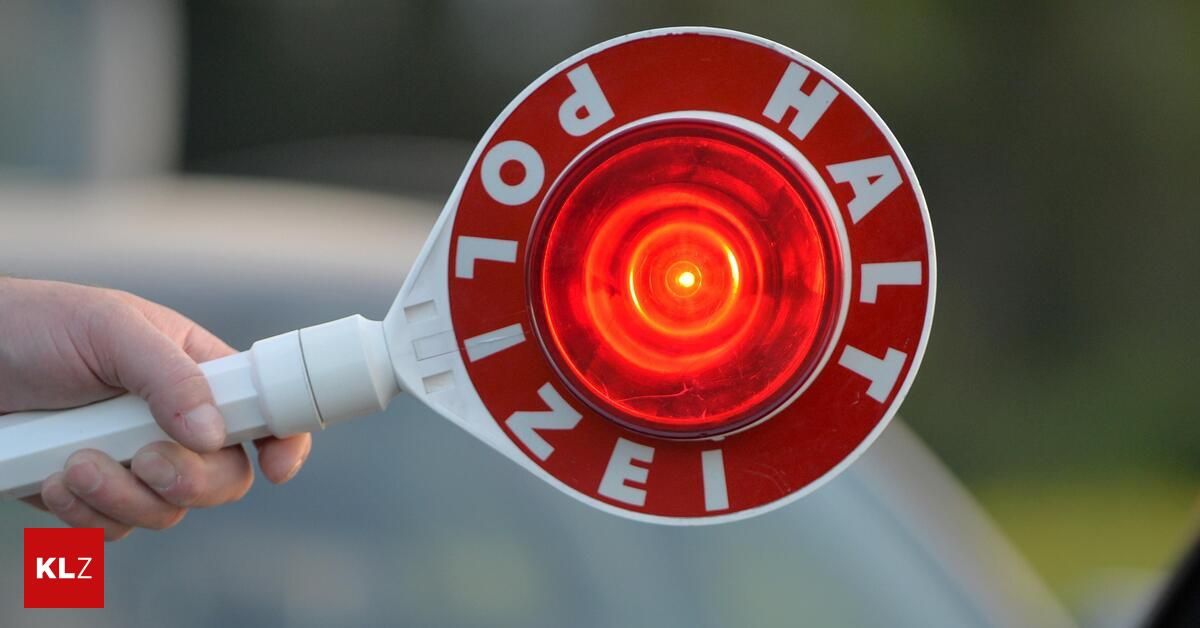 Ein Nahaufnahme einer roten Ampel mit dem Wort 'Halt' in weiß auf rotem Hintergrund. Die Lampe ist beleuchtet und zeigt ein Stoppsignal an.