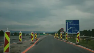 Eine Autobahn mit einem Geschwindigkeitsschild von 60 km/h und einem blauen Schild, das auf Wien zeigt.