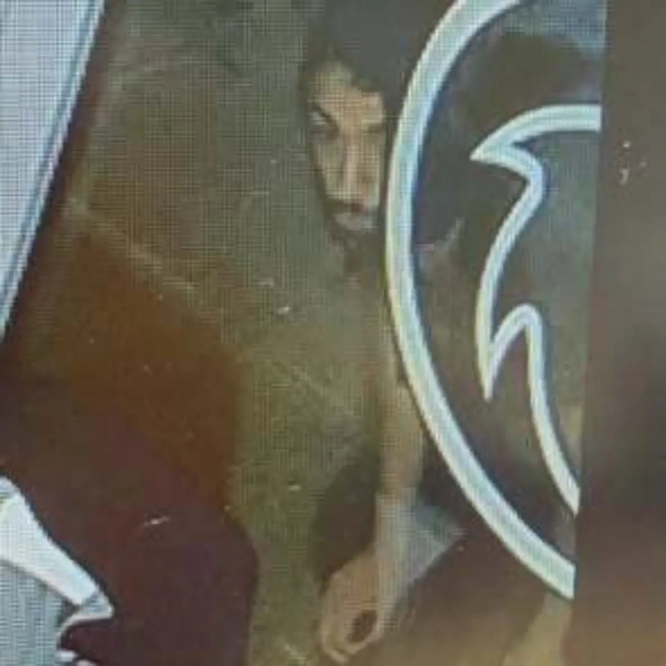 Ein verschwommenes Bild zeigt eine Person, die auf dem Boden sitzt, mit einem Logo im Hintergrund.