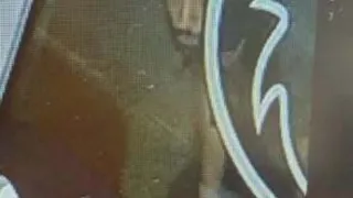 Ein verschwommenes Bild zeigt eine Person, die auf dem Boden sitzt, mit einem Logo im Hintergrund.