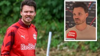 Ein Fußballspieler in einem roten Trikot mit dem Wort RedBull darauf sieht wütend aus. Eingesetzt, ein Mann mit einem Kronen Zeitung-Abzeichen auf seinem Hemd.