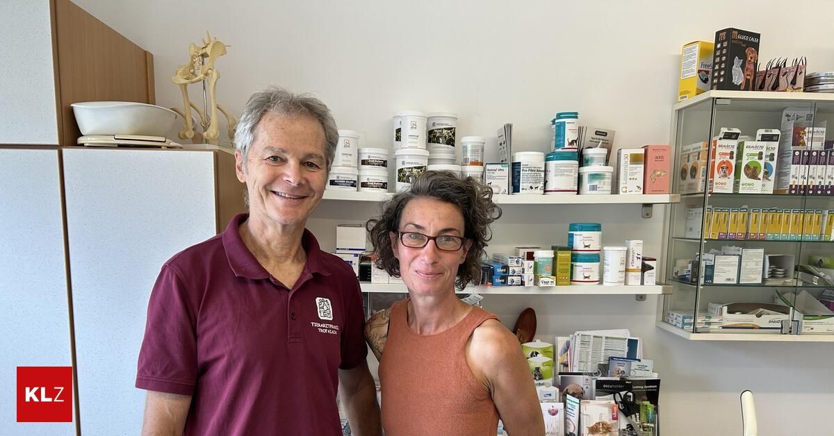 Ein Mann und eine Frau stehen vor einem Regal mit verschiedenen Produkten und lächeln für die Kamera. Der Mann trägt ein weinrotes Poloshirt und die Frau ein ärmelloses Top. Hinter ihnen sind Regale mit Behältern und Kisten gefüllt.