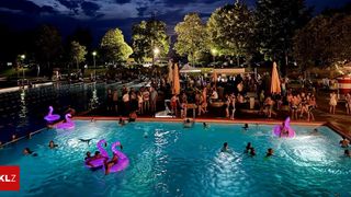 Eine nächtliche Poolparty mit Menschen, die im Pool schwimmen und auf der Poolterrasse entspannen. Bäume und Straßenlaternen sorgen für Beleuchtung.