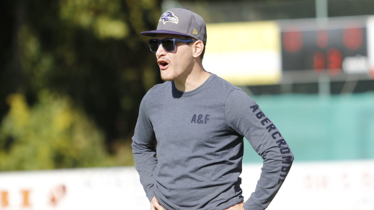 Ein Mann in einem grauen Langarmshirt mit 'A&F' und einer Baltimore Ravens-Kappe steht draußen, wahrscheinlich auf einem Sportplatz.