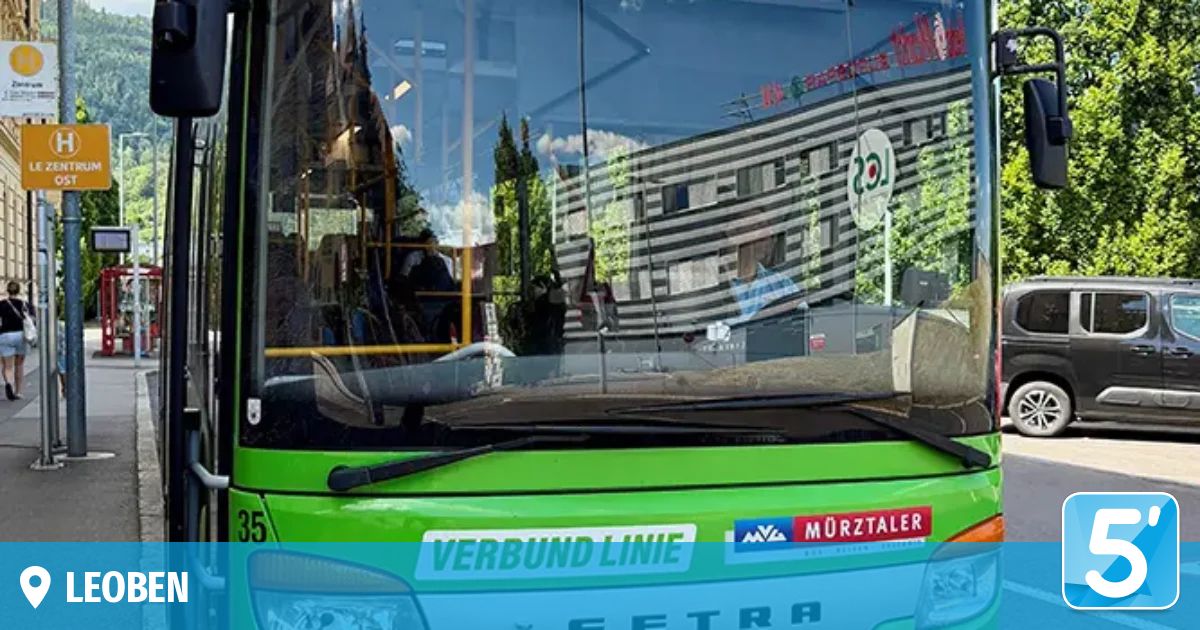 Ein grüner Bus mit der Aufschrift 'VERBUND LINIE' auf der Front, Nummer 35, und einem Logo von 'MURZTALLER'. Die Windschutzscheibe spiegelt ein Gebäude und Bäume wider.