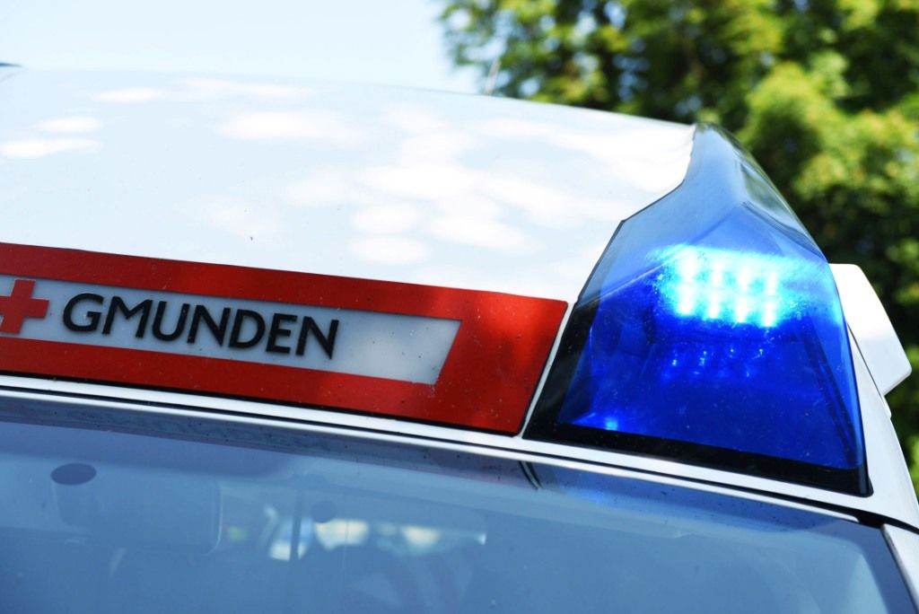 Nahaufnahme eines Polizeiwagens mit dem Wort 'MUNDEN' an der Seite und einem blauen blinkenden Licht oben.