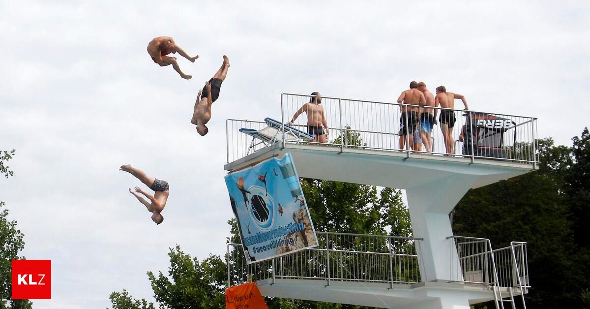 Mehrere junge Männer springen von einer Sprungturm in einen Pool. Einige tauchen ab, während andere auf dem Sprungturm stehen.