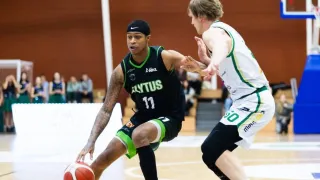Ein Basketballspieler in einem schwarzen Trikot mit der Nummer 11 dribbelt den Ball, während ein anderer Spieler in einem weißen Trikot versucht, ihn zu blocken.