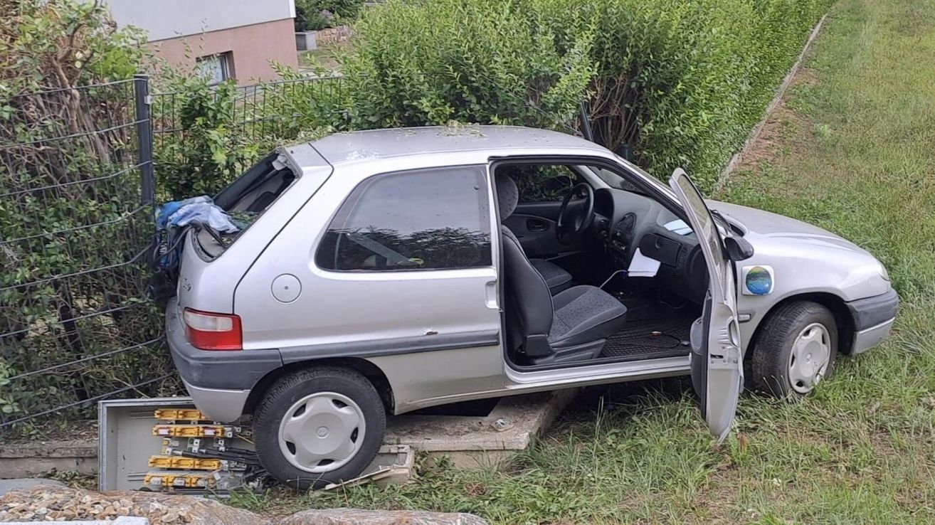 Ein silbernes Auto mit offener Tür und eingeschlagener Front in einen Busch.