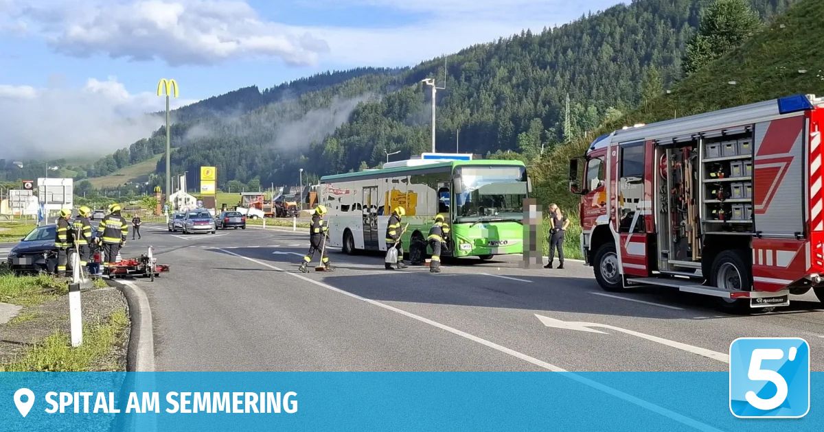 Ein grüner Bus steht am Straßenrand, Feuerwehrleute sind dabei, etwas aufzuräumen. Im Hintergrund ist ein McDonald's-Schild zu sehen.