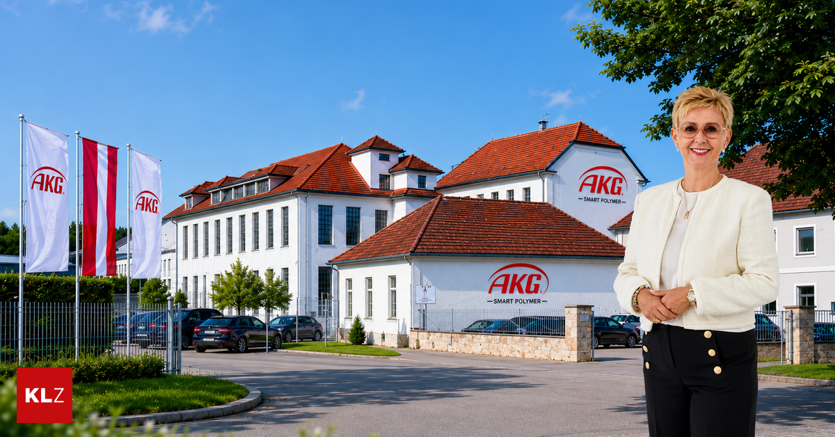 Eine Frau steht vor einem großen weißen Gebäude mit roten Dächern und einem roten Logo, das AKG Smart Polymer liest. Mehrere Autos sind vor dem Gebäude geparkt.