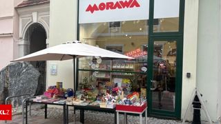 Ein Buchladen mit dem Namen Morawa, der Bücher und Spielzeug vor dem Laden unter einem Regenschirm ausstellt.