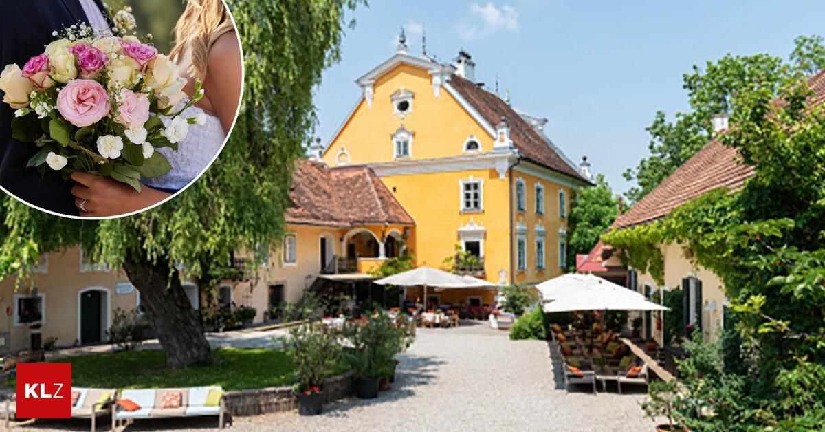 A yellow villa with a brown roof and white trim stands in a garden with a large tree and a woman holding a bouquet of flowers.