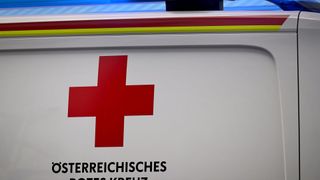 Nahaufnahme eines weißen Hintergrunds mit einem roten Kreuzsymbol und den Worten 'TERREICHISCHES ROTES KREUZ' in schwarzer Schrift.