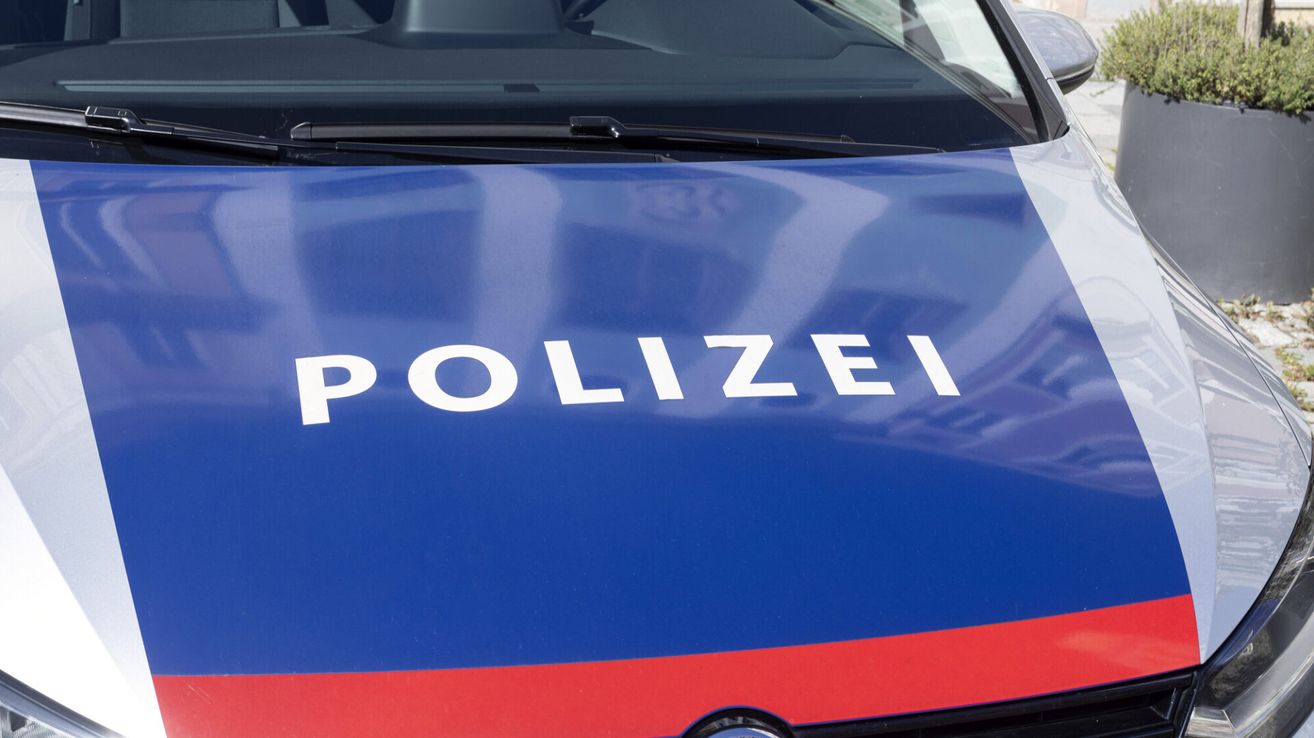 A close-up view of a blue police vehicle with the word 'POLIZEI' in white letters on the front hood.