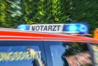 A blurred image of a red emergency vehicle with 'NOTARZT' written on its roof, indicating it is a medical emergency vehicle.