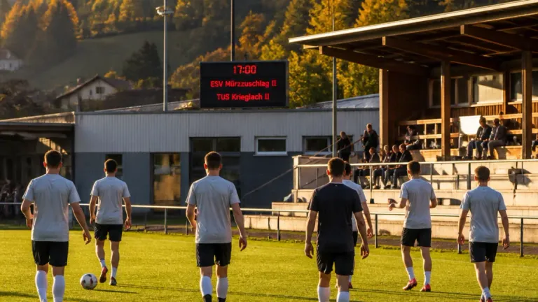 Fünf Fußballspieler laufen auf einem Feld. Eine Anzeigetafel zeigt die Zeit als 17:00. Zuschauer sitzen auf Tribünen hinter einem Gebäude.