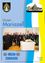 Eine Gruppe von Geistlichen und Beamten steht vor einem Tisch mit einer Statue und einem Buch, mit einem Banner im Hintergrund.
