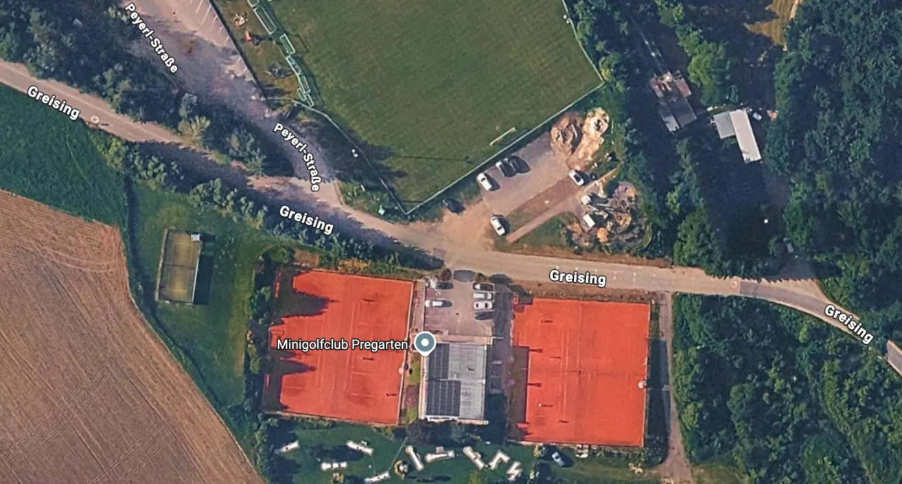 Aerial view of a tennis club with red courts, a parking lot, and a road named Greising.