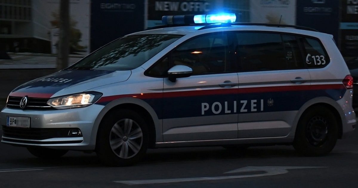 Ein Polizeifahrzeug mit blauen Lichtern auf dem Dach ist am Straßenrand geparkt.
