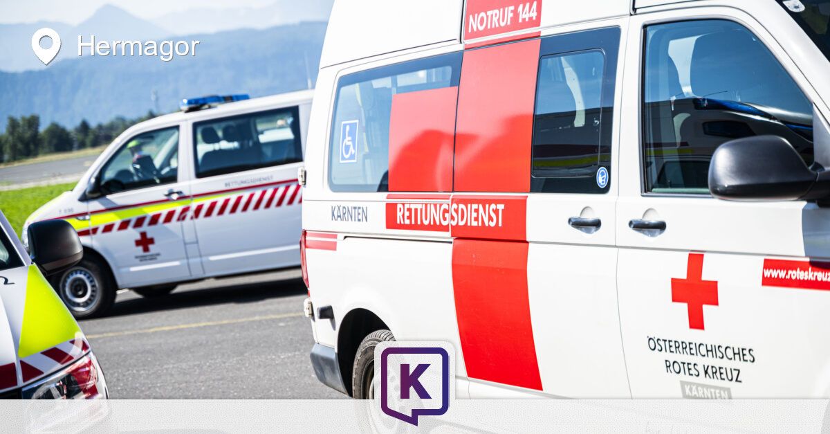 Ein weißer Krankenwagen mit roten und weißen Streifen und den Aufschriften 'Notruf 144' und 'Rettungsdienst' an der Seite. Ein weiterer Krankenwagen ist dahinter geparkt.