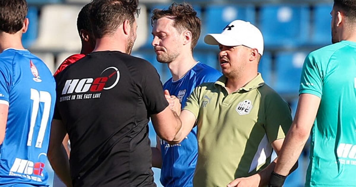 Three men in sports attire are engaged in a discussion, with one wearing a black shirt with a logo, another in a blue shirt, and the third in a green polo with a white cap.