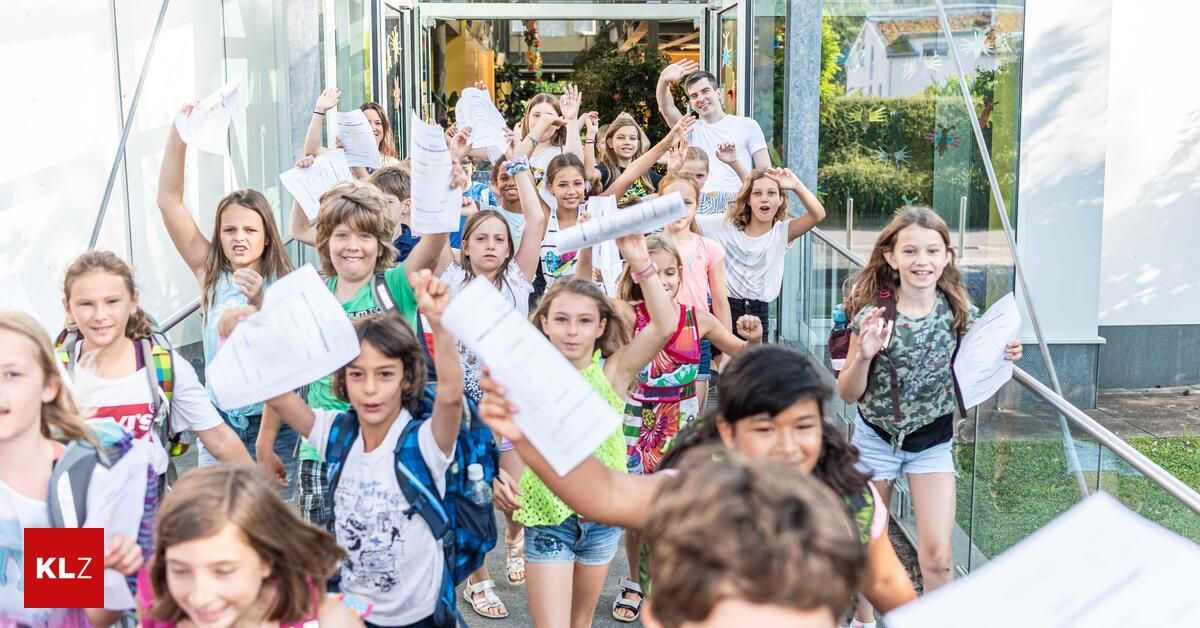 A group of children with backpacks are holding up papers and smiling, possibly celebrating a school event.