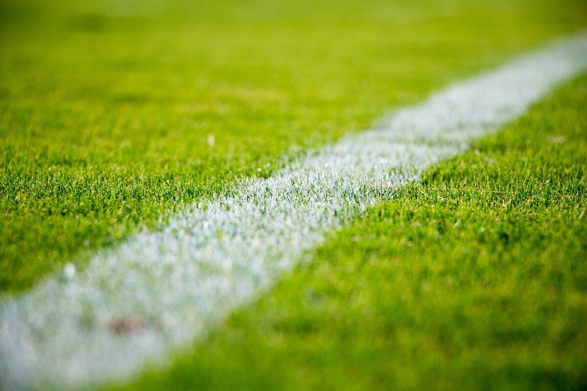 Eine Nahaufnahme eines Fußballfeldes mit einer weißen Linie, die die Grenze markiert.