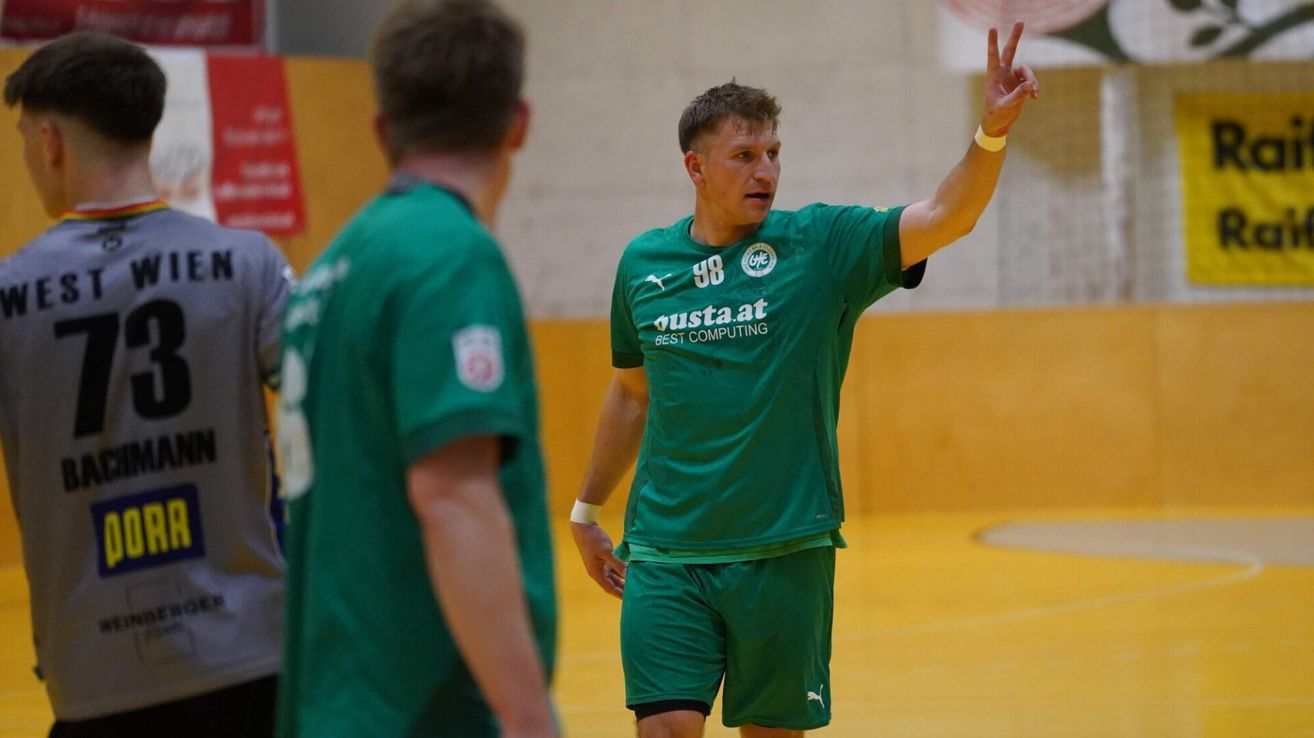 A man in a green jersey with the number 98 on it is gesturing with his hand in a sports setting.