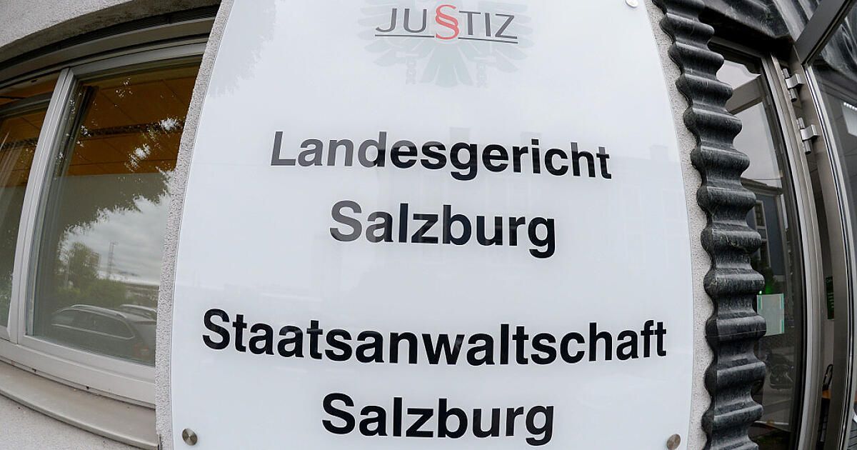 A white sign with black text mounted on a wall. It reads 'Justiz' at the top, followed by 'Landesgericht Salzburg' and 'Staatsanwaltschaft Salzburg'.