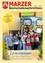 Eine Gruppe von Kindern und zwei Frauen steht vor einem farbenfrohen Buchautomaten. Die Kinder halten Bücher in den Händen und lächeln. Der Automat hat ein Schild mit der Aufschrift 'Bücherzelle'.