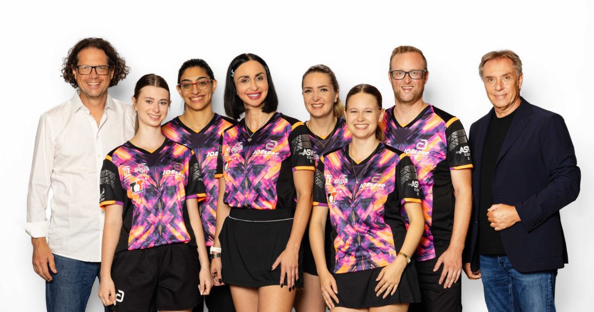 Eine Gruppe von Personen, wahrscheinlich ein Sportteam, posiert für ein Foto. Sie tragen alle passende Uniformen mit einem lebhaften Design.