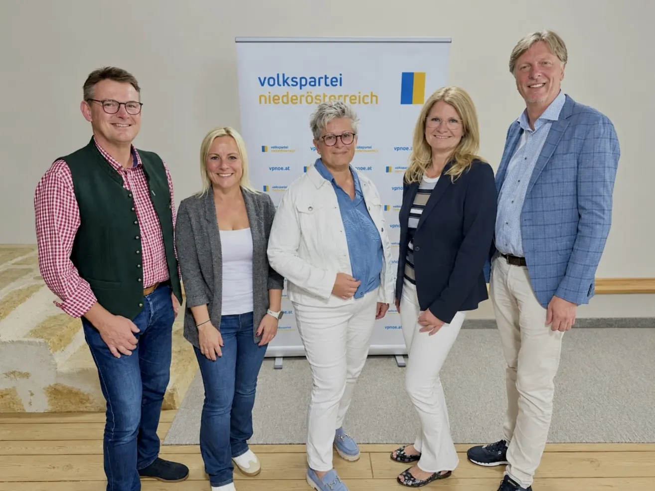 Five individuals stand together in front of a banner with the text 'volkspartei niederosterreich'. They are all smiling and appear to be posing for a photograph.