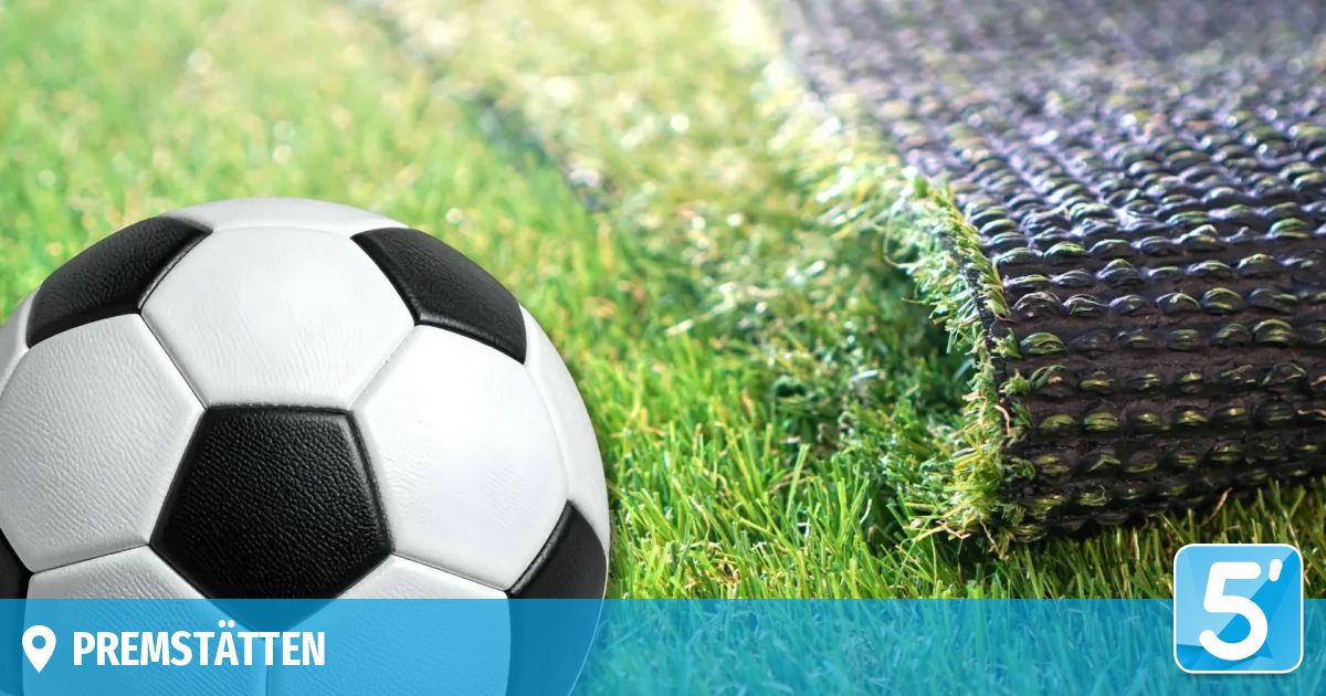 Ein Nahaufnahme eines weißen und schwarzen Fußballs auf einem grünen Rasen mit einem blauen Rand.