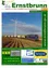 Ein Plakat für die Gemeinde Ernstbrunn mit einem Zug auf der Schiene und einer Windmühle im Hintergrund.