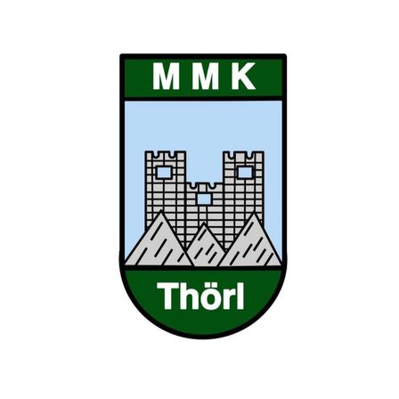 Das Emblem zeigt eine stilisierte Burg mit einem Bergrücken im Hintergrund, vor einem blauen Himmel. Die Buchstaben 'MMK' sind deutlich über der Burg angebracht, und der Name 'Thorl' steht darunter in einer geschwungenen Schrift.