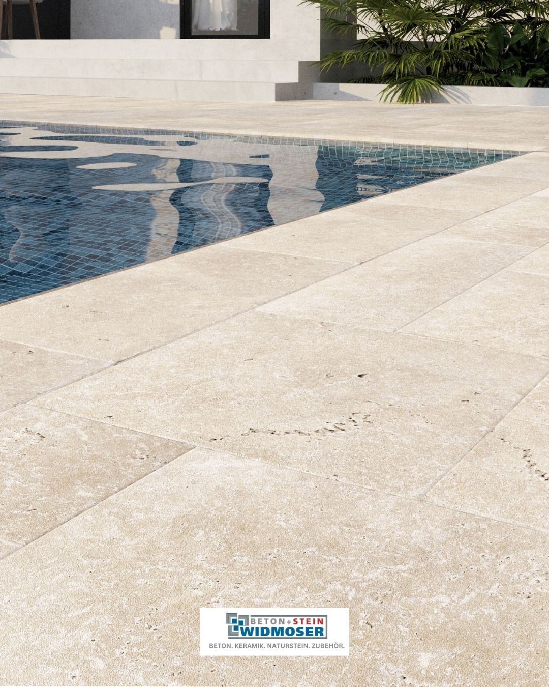 Ein großer Swimmingpool mit blauen Fliesen und einem beigefarbenen Fliesenboden daneben. Das Wasser spiegelt die Umgebung wider.